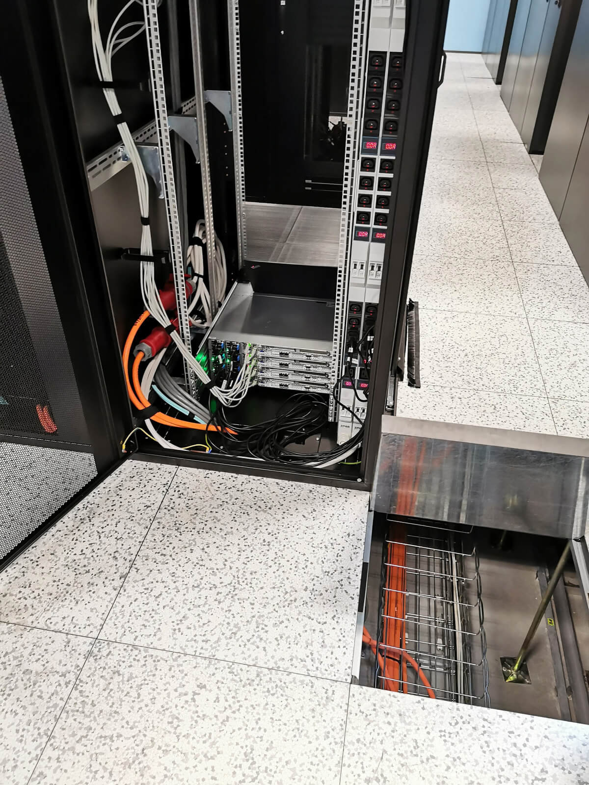 Szafa rack z okablowaniem i listwami PDU w serwerowni